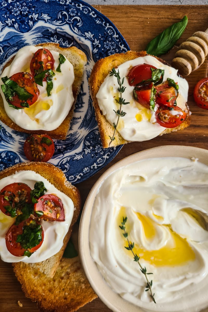 Gezouten bruschetta's met opgeklopte ricotta, gemarineerde tomaten en honing